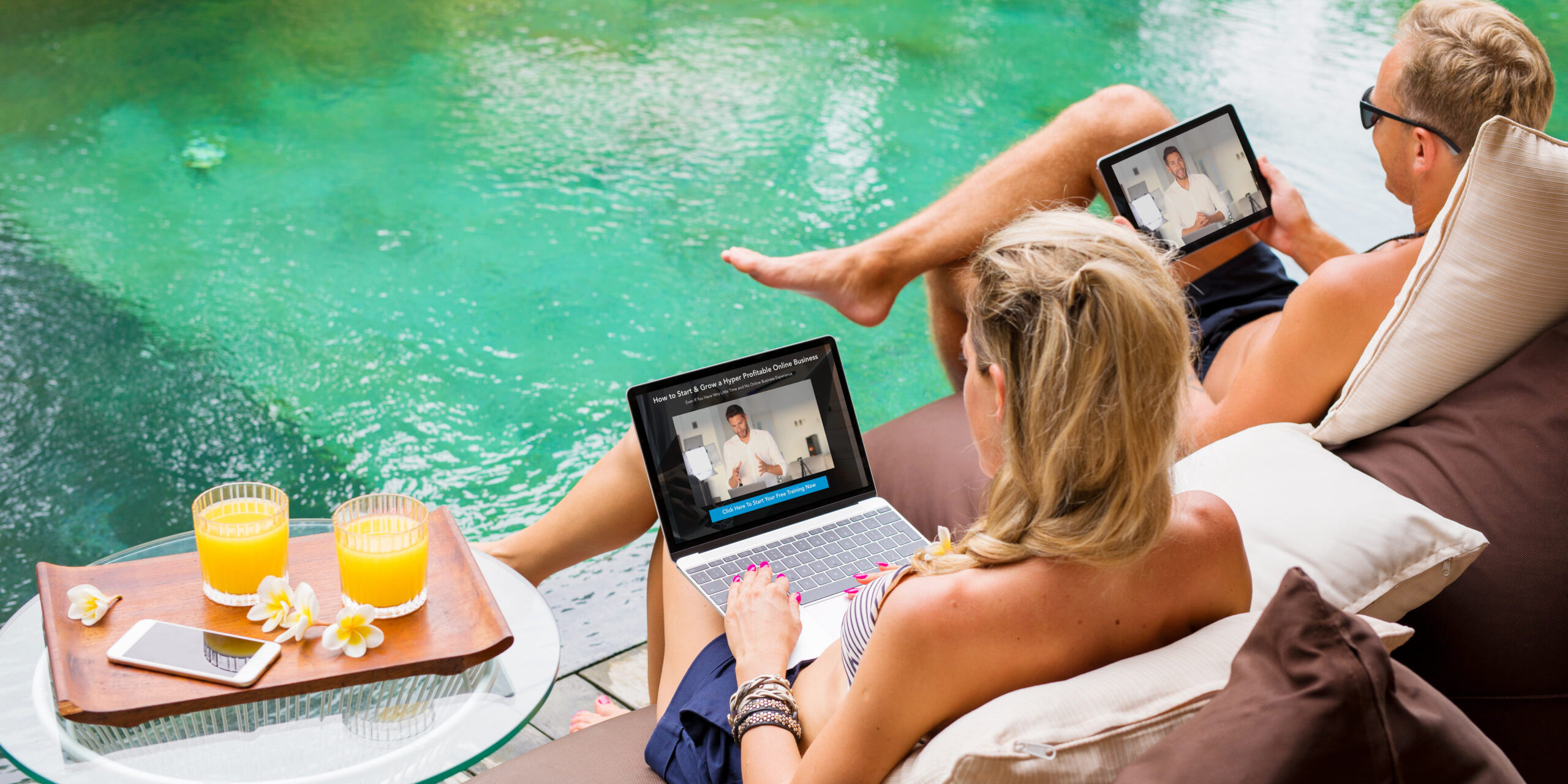 Poolside Productivity: A Couple’s Digital Lifestyle A couple relaxing by a pool, each using a laptop to watch videos about how to work online and make money, with a tray of fresh juice and flowers on a nearby table.